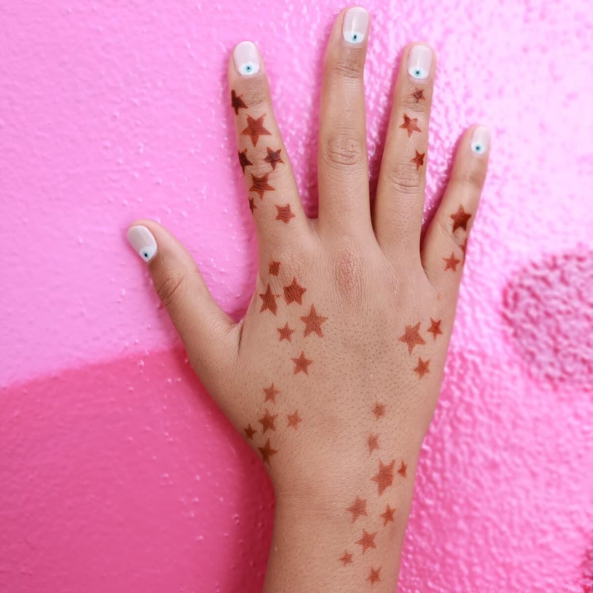 Stellar - henna tattoo star pattern on pink background