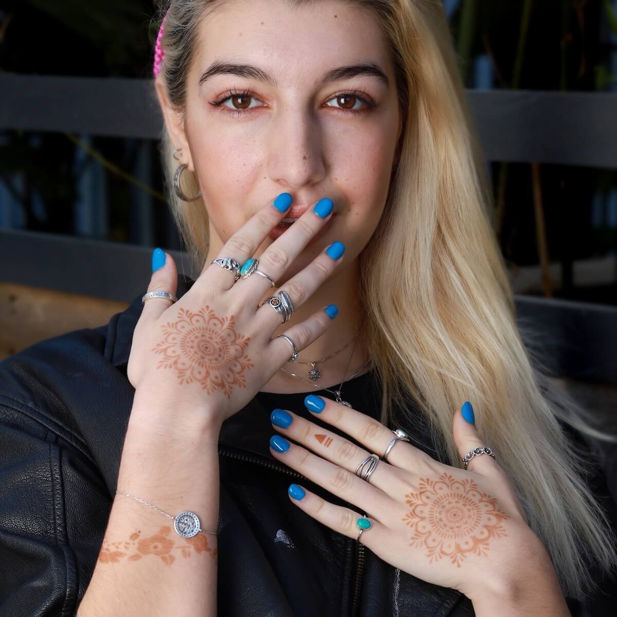 Woman with mandala henna tattoos on the backs of both her hands