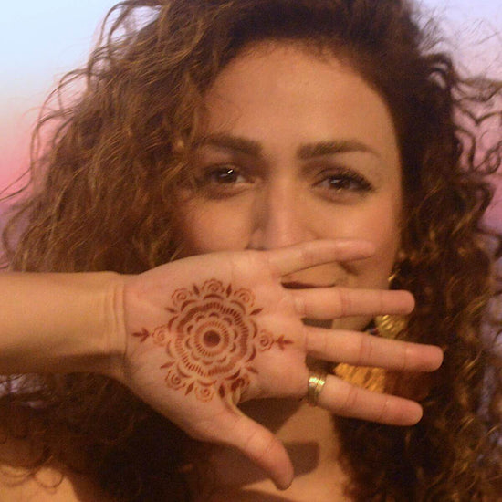 Camellia - Woman with mandala henna tattoo on palm