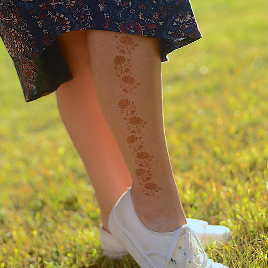 Jasmine - Woman in dress with floral henna tattoos on leg
