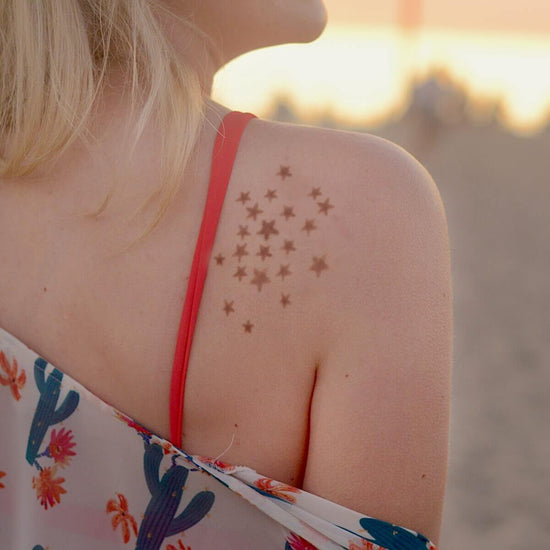 Stellar - woman with star henna tattoo on shoulder