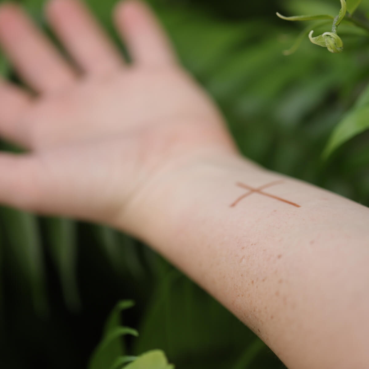 Truth - minimalist cross henna design on wrist