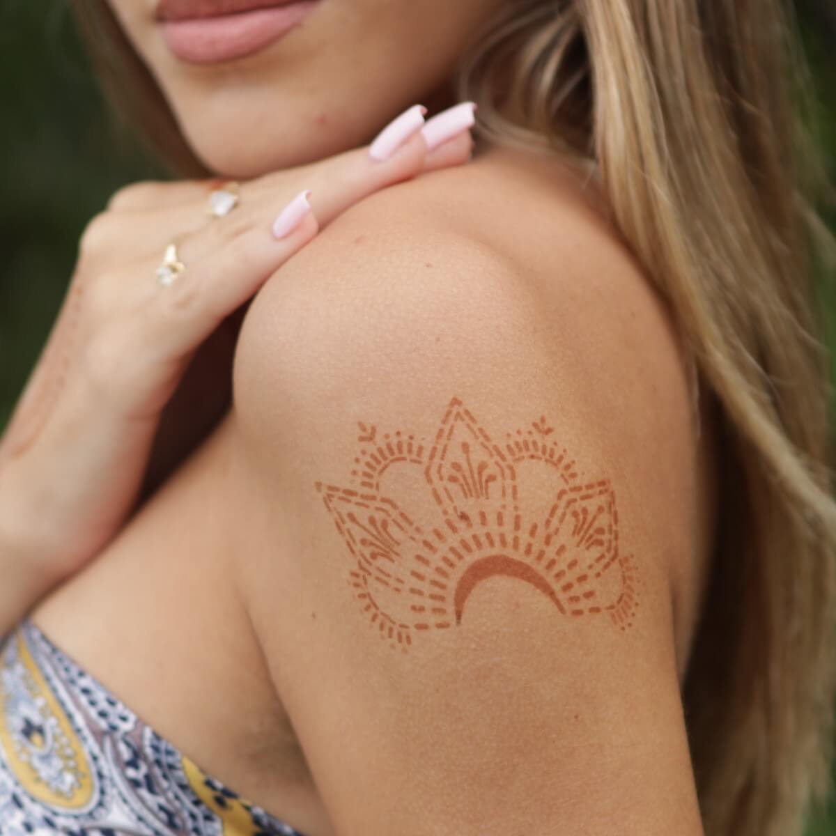 Knuckle Star - curved henna tattoo on woman's shoulder