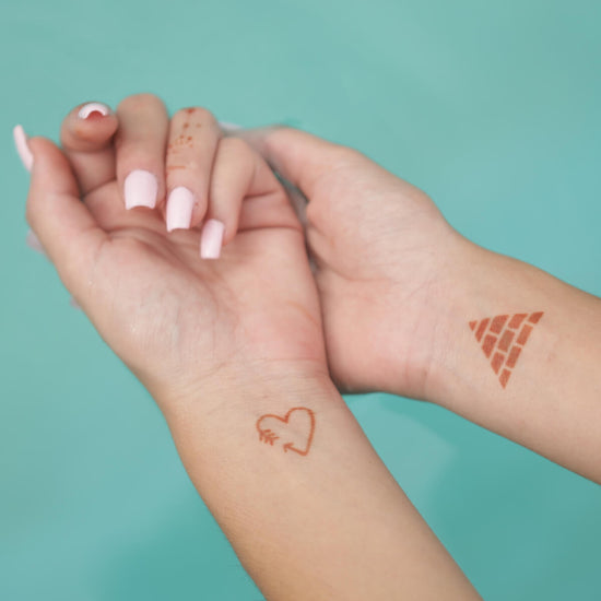 Sand - mini henna tattoos of heart and pyramid on wrists