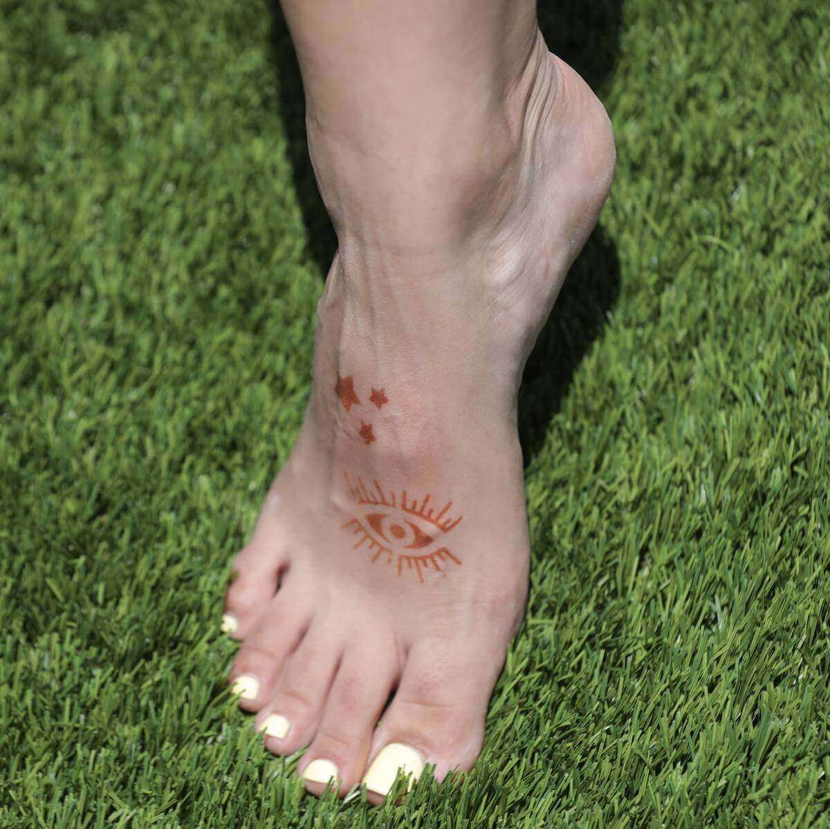Sun - small stars and evil eye temporary tattoo on foot